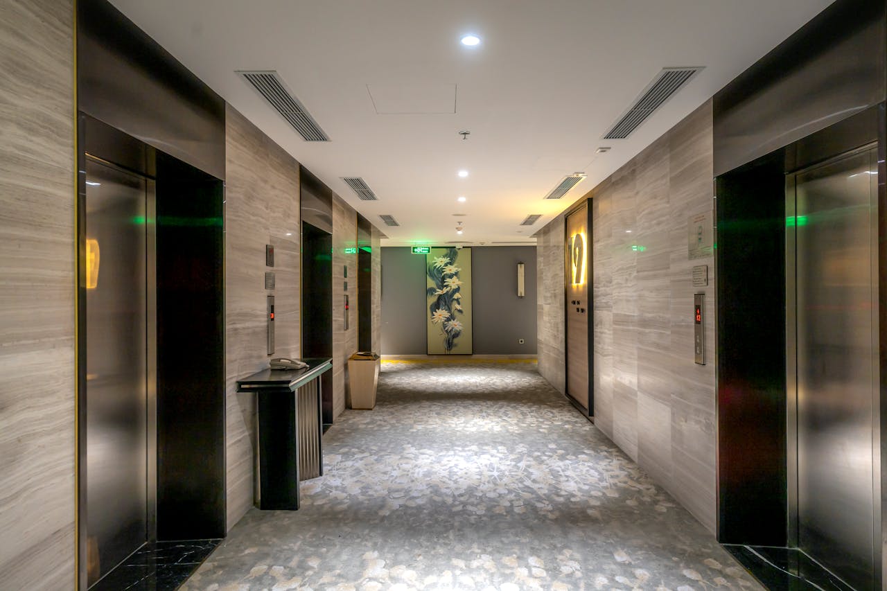 Spacious hotel hallway with elevators and contemporary decor.